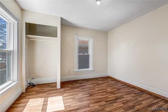 unfurnished bedroom featuring a closet, baseboards, and light wood-style floors