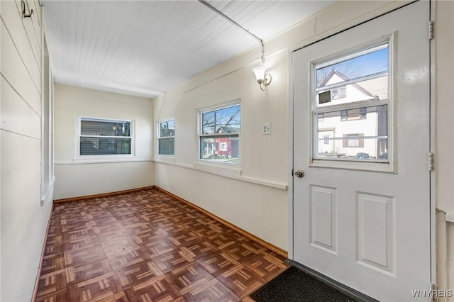 doorway to outside with baseboards and a wealth of natural light