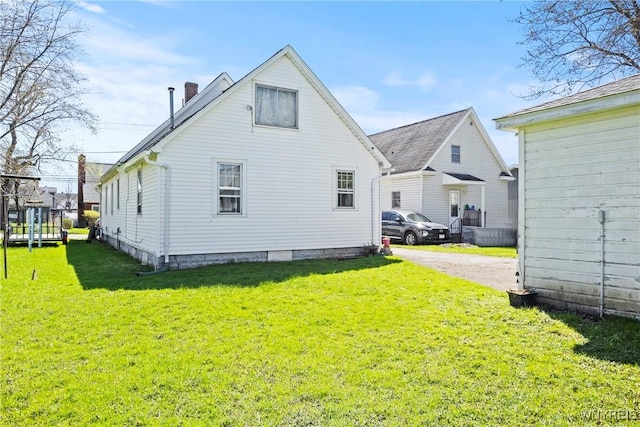 rear view of house featuring a yard and a chimney