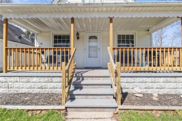 view of exterior entry featuring covered porch