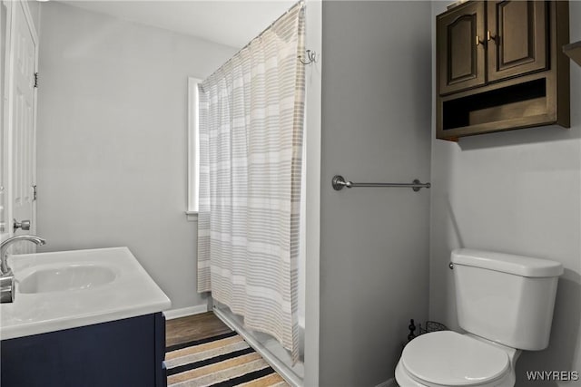 bathroom featuring vanity, baseboards, and toilet