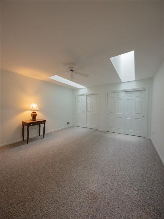 basement featuring carpet floors, ceiling fan, and baseboards