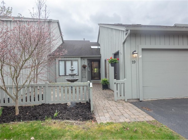 view of front of house with an attached garage and roof with shingles