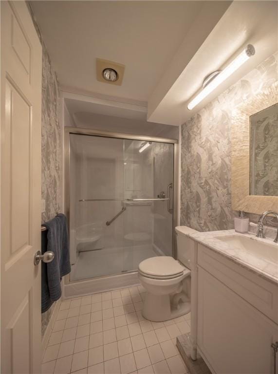 bathroom featuring tile patterned flooring, vanity, toilet, wallpapered walls, and a shower stall