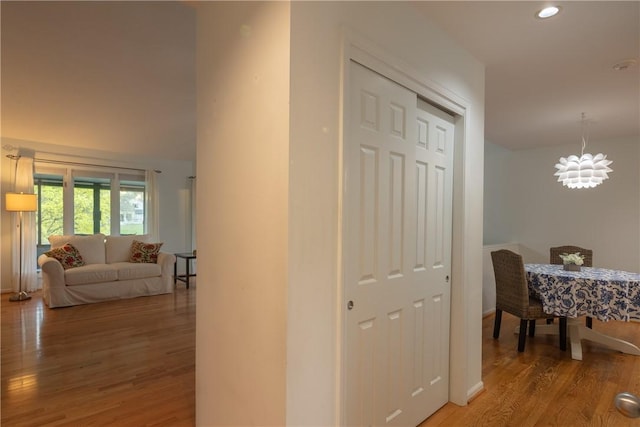 hallway featuring baseboards, recessed lighting, and wood finished floors