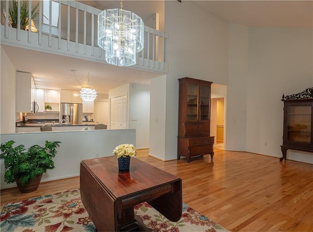 living room featuring a high ceiling, light wood-type flooring, and a chandelier