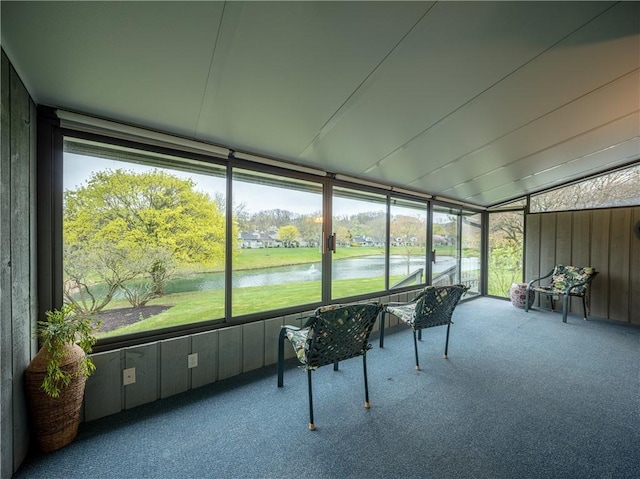 sunroom featuring a water view