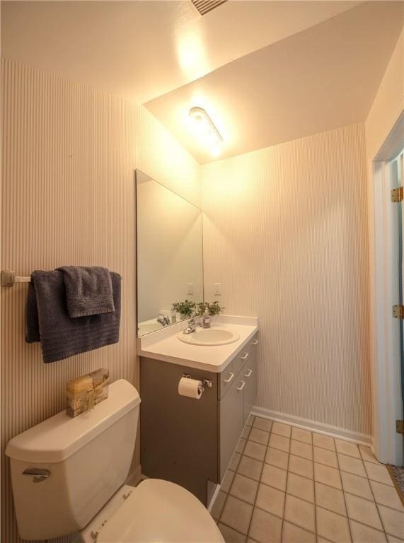 bathroom with vanity, tile patterned flooring, baseboards, and toilet
