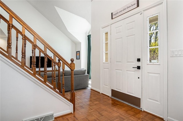 foyer entrance featuring stairs and visible vents