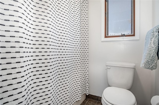 bathroom featuring wood finished floors and toilet