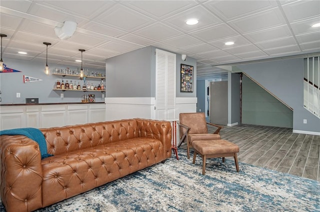 living room with recessed lighting, wood finished floors, stairway, and indoor bar