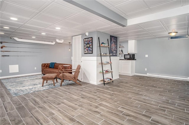 sitting room featuring baseboards, a baseboard radiator, recessed lighting, and wood finished floors