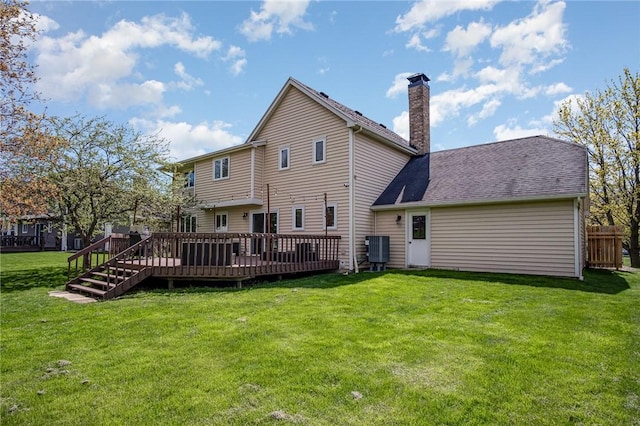 back of house with a wooden deck, a chimney, and a yard