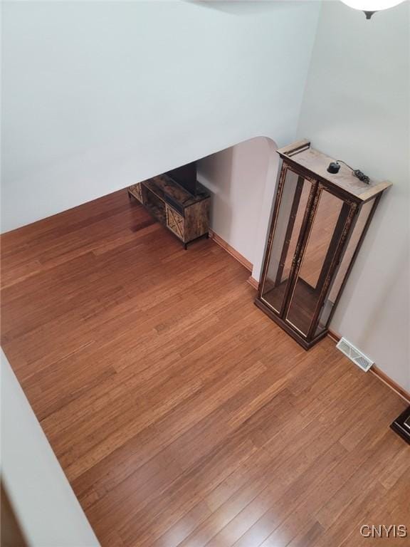 stairway featuring baseboards, visible vents, and wood finished floors