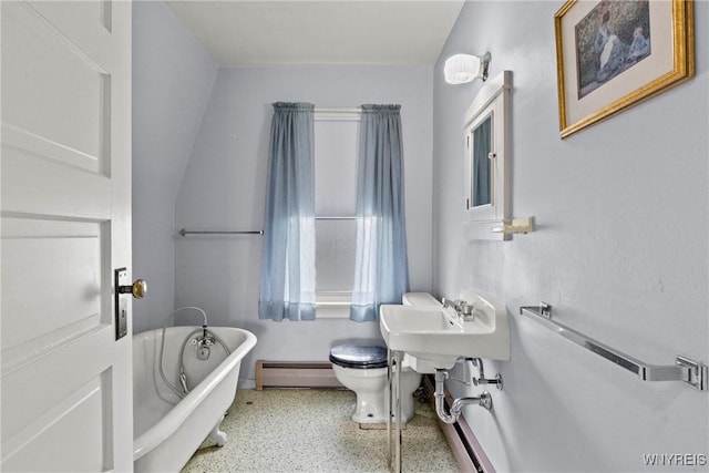 bathroom with a freestanding bath, baseboard heating, toilet, speckled floor, and baseboards