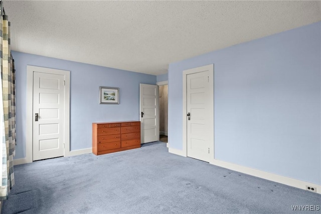 unfurnished bedroom with baseboards, carpet, and a textured ceiling