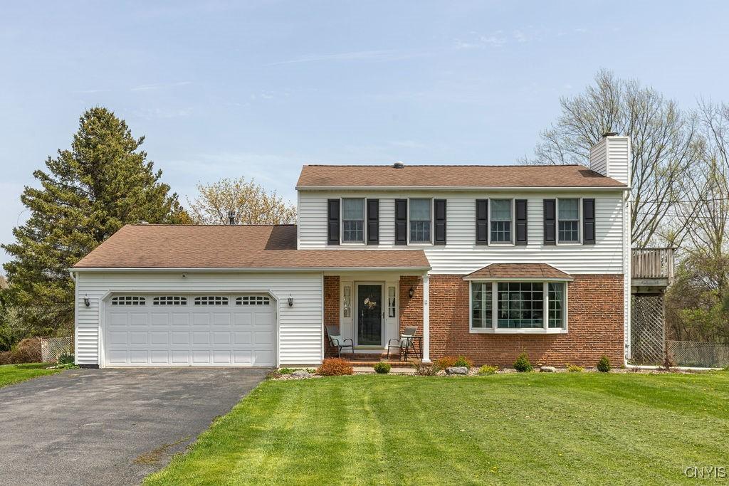 4360 Cleveland Rd, Onondaga, NY 13215 - traditional home featuring a garage, a front yard, a chimney, brick siding, and driveway