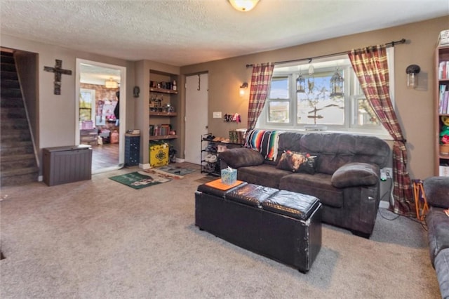 living area with stairway, carpet, and a textured ceiling