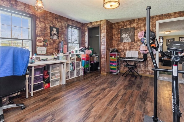 office space featuring baseboards, a textured ceiling, and wood finished floors