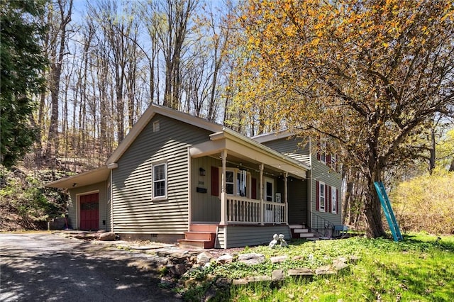 traditional home featuring a porch, driveway, and crawl space