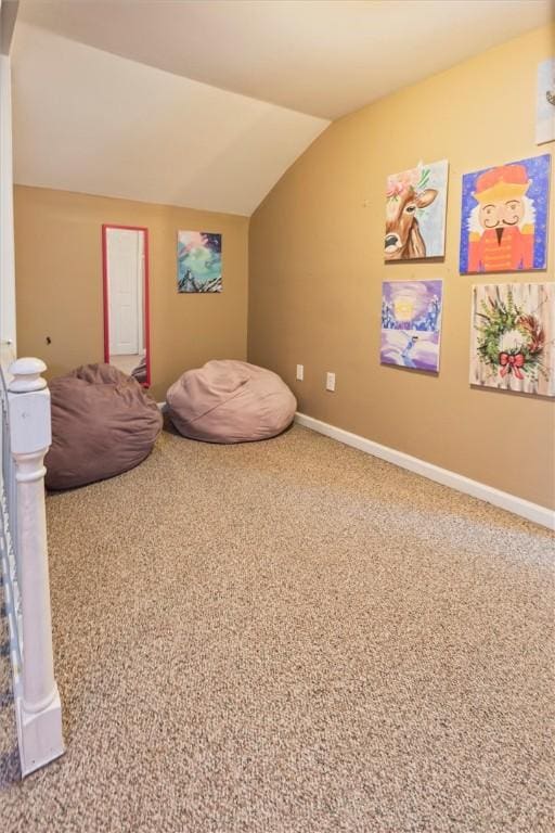 sitting room with carpet floors, baseboards, and vaulted ceiling