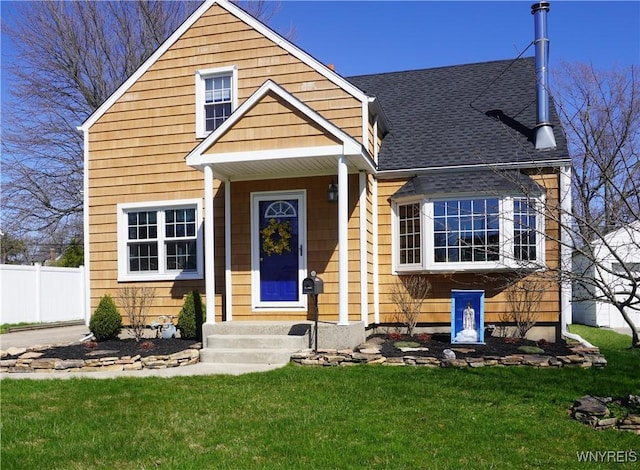 bungalow-style home featuring a shingled roof, a front lawn, and fence