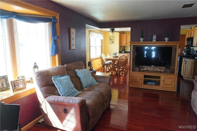 living room featuring visible vents, ceiling fan, and wood finished floors