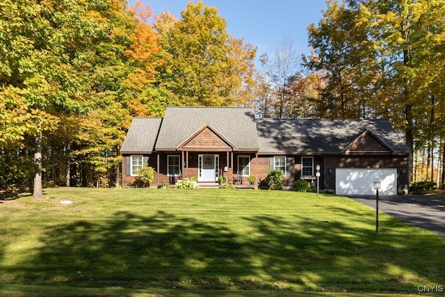 view of front of home with a porch, a garage, a front lawn, and aphalt driveway