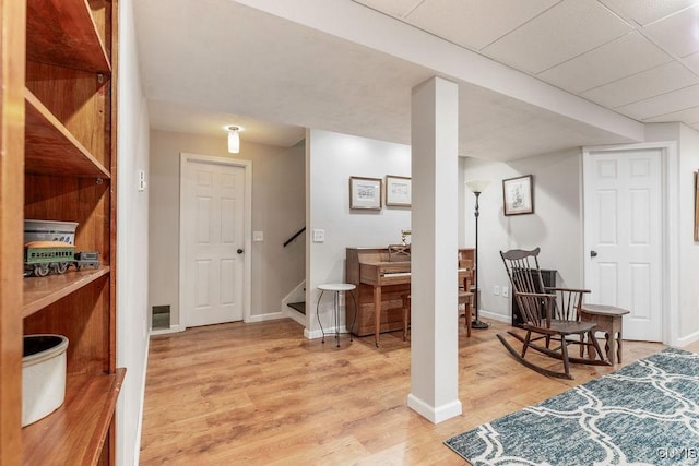 interior space with baseboards, light wood-type flooring, and visible vents