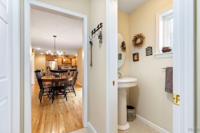 bathroom featuring baseboards, an inviting chandelier, and wood finished floors