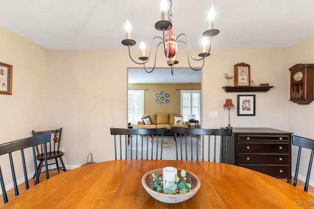 dining area featuring baseboards and a notable chandelier