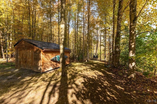 view of shed with a wooded view