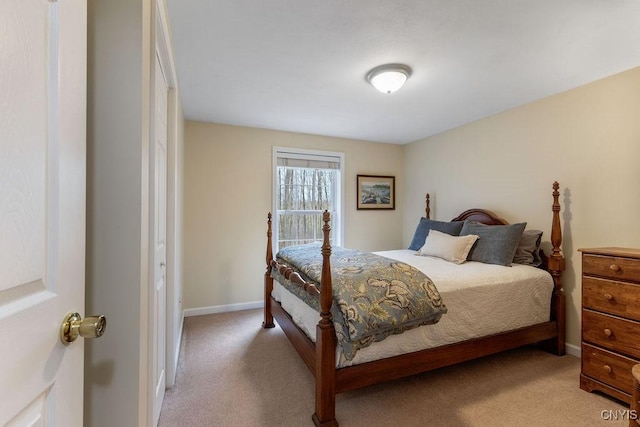 bedroom with baseboards and light colored carpet