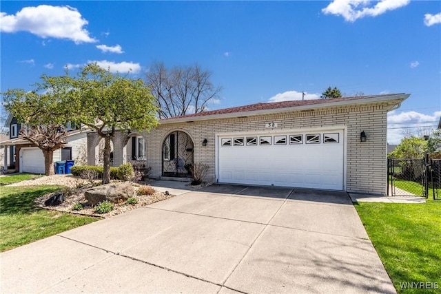 view of front of house with driveway, a front yard, a garage, brick siding, and fence