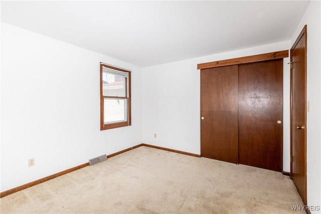 unfurnished bedroom featuring a closet, baseboards, carpet flooring, and visible vents