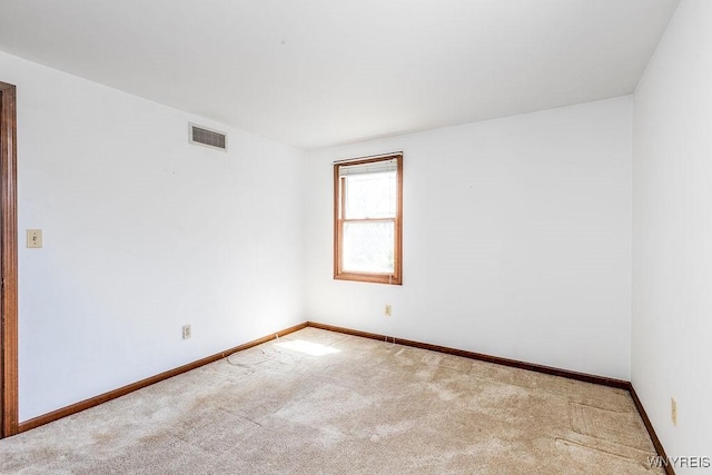 carpeted empty room featuring baseboards and visible vents