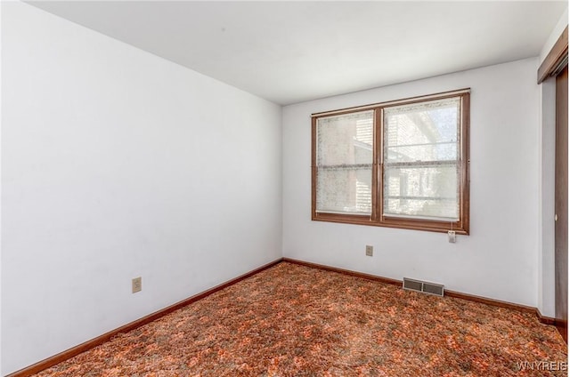 spare room with visible vents, carpet, and baseboards