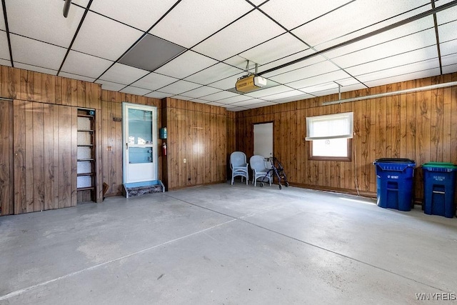 garage with a garage door opener and wooden walls