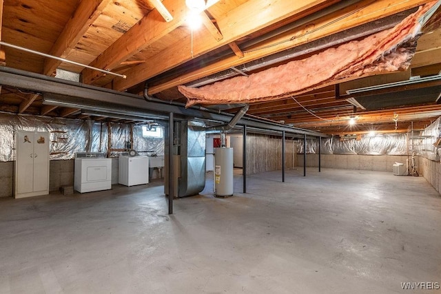 basement with a sink, heating unit, gas water heater, and washer and dryer