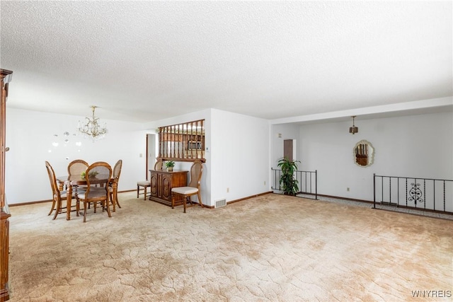 interior space with visible vents, a textured ceiling, carpet floors, and a notable chandelier