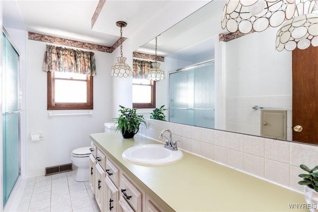 bathroom featuring vanity, toilet, tile patterned floors, a shower stall, and visible vents