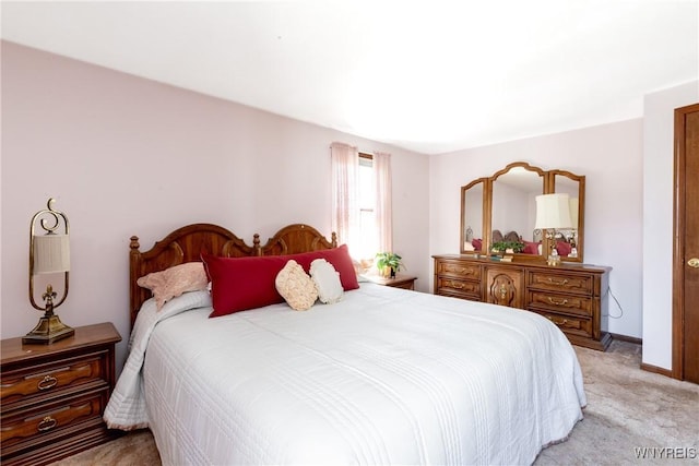 bedroom with baseboards and light carpet