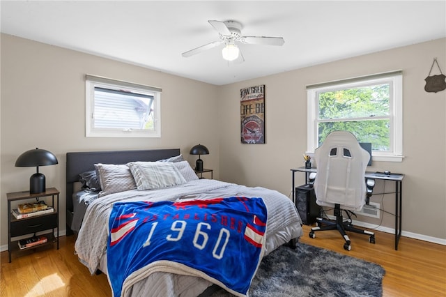 bedroom featuring baseboards, multiple windows, and wood finished floors