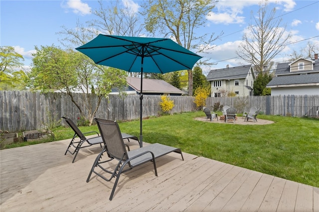deck featuring a fenced backyard, a lawn, a fire pit, and a patio area