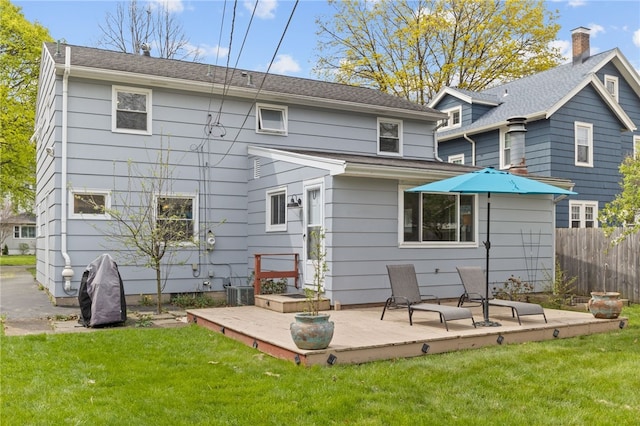rear view of property with a lawn and fence