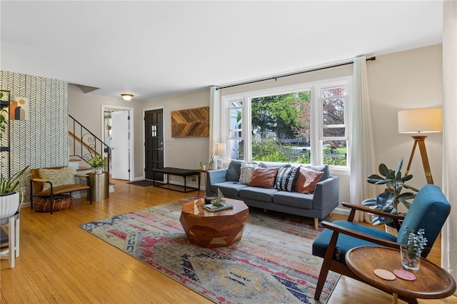 living area with light wood-style flooring and stairs