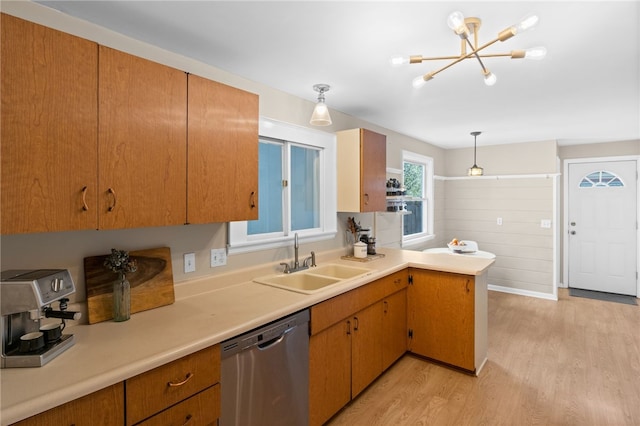 kitchen with a sink, dishwasher, a notable chandelier, and light countertops