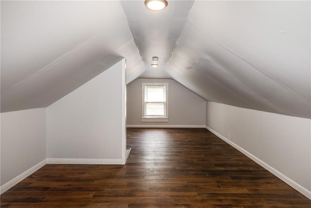 bonus room with baseboards, vaulted ceiling, and wood finished floors