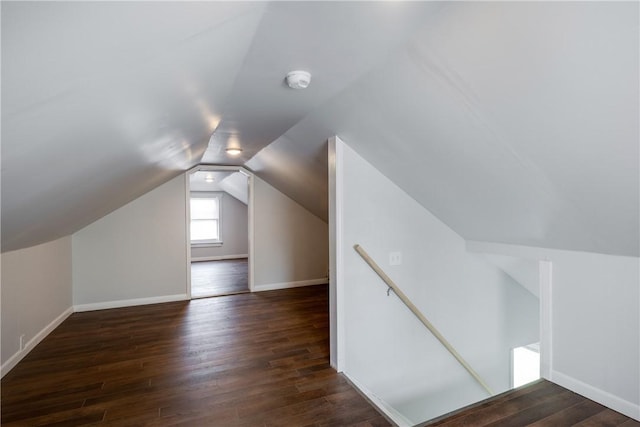 additional living space featuring baseboards, wood finished floors, and vaulted ceiling