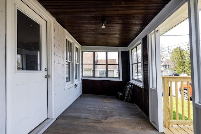 unfurnished sunroom with wood ceiling and wood finished floors